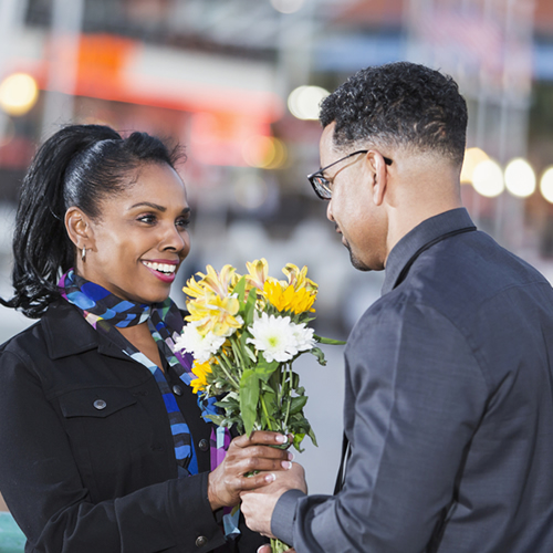 man-giving-flowers-to-young-latino-woman_500x500