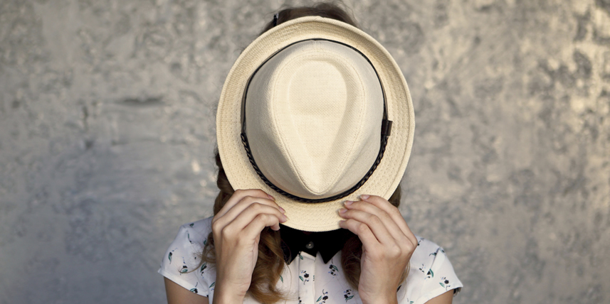 woman-hiding-behind-a-hat
