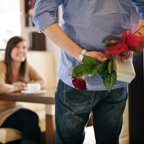 man-hiding-gift-and-flowers-for-woman